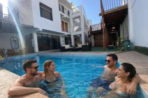 a group of people sitting in a swimming pool at Aura house in Huanchaco