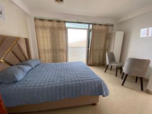 a bedroom with a bed and a large window at Aura house in Huanchaco