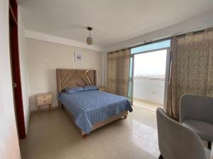 a bedroom with a bed and a large window at Aura house in Huanchaco
