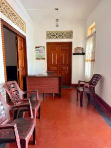 a room with chairs and a desk and a door at Bon Voyaage Villa in Trincomalee