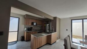 a kitchen with wooden cabinets and a large window at Amplia casa equipada para familia, pareja o individual in Tizayuca