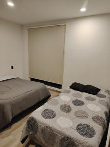 a bedroom with two beds and a large window at Amplia casa equipada para familia, pareja o individual in Tizayuca