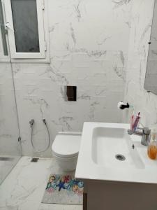 a white bathroom with a sink and a toilet at Primavera Marmara Hamam sousse in Hammam Sousse +38 photos