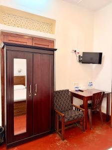 a room with a wooden cabinet and a table with a chair at Bon Voyaage Villa in Trincomalee +9 photos
