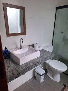 a bathroom with a sink and a toilet and a mirror at Suíte Recanto dos poetas 07 in Lençóis