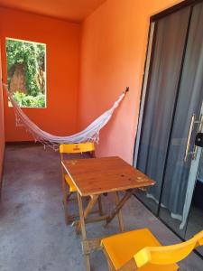 a hammock in a room with a table and chairs at Suíte Recanto dos poetas 07 in Lençóis