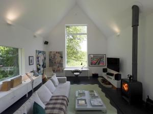 a living room with a white couch and a fireplace at Croft Lodge Studio in Leominster +30 photos