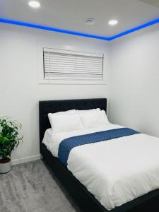 ein Schlafzimmer mit einem Bett und blauer Decke in der Unterkunft Ivey Homes in Edmonton