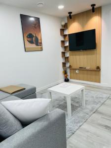 ein Wohnzimmer mit einer Couch und einem Fernseher an der Wand in der Unterkunft Ivey Homes in Edmonton
