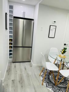 eine Küche mit einem Edelstahlkühlschrank sowie einem Tisch und Stühlen in der Unterkunft Ivey Homes in Edmonton