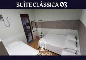 two beds in a room with avisorvertisement at Pousada Encosta da Fé - Unidade Centro in Juazeiro do Norte