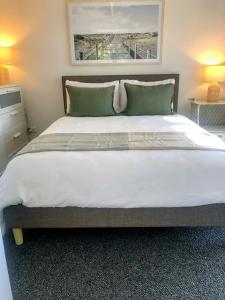 a bedroom with a large white bed with two pillows at Rye Hide Out - Rye beach retreat in Rye