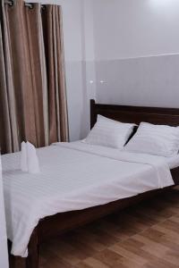 a bed with white sheets and pillows in a bedroom at 5H homestay & Motorbikes For Rent in Hue