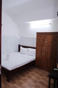 a bedroom with a bed and a wooden cabinet at 5H homestay & Motorbikes For Rent in Hue +3 photos
