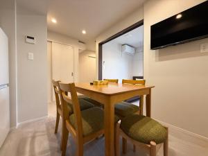a dining room with a wooden table and chairs at PRISM Inn Ikegami Kamata in Tokyo