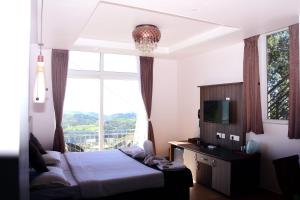 a bedroom with a bed and a large window at Vanam Holidays in Ooty