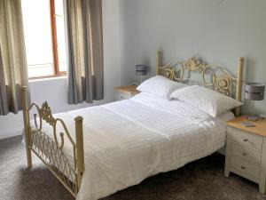 a bedroom with a large bed and two night stands at Rosecraddoc Manor - Riverbank in Saint Cleer