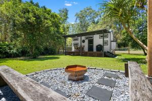 a tiny house with a fire pit in the yard at Rural Oasis - Tiny Home 2BR Cabin & Outdoor Firepit Experience in Palmwoods