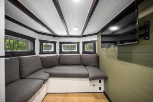 a small couch in the corner of a tiny house at Rural Oasis - Tiny Home 2BR Cabin & Outdoor Firepit Experience in Palmwoods