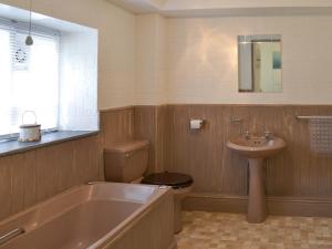 a bathroom with a tub and a toilet and a sink at Rosecraddoc Manor - Natalie Jane in Saint Cleer