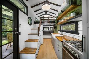 an interior view of a kitchen in a tiny house at Rural Oasis - Tiny Home 2BR Cabin & Outdoor Firepit Experience in Palmwoods