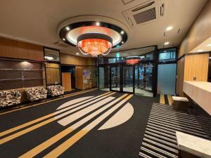 a room with a hallway with chairs and a chandelier at APA HOTEL Fukushima Ekihigasi in Fukushima