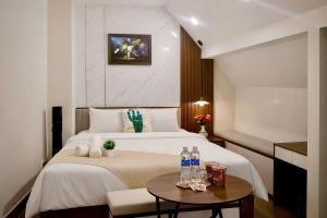 a hotel room with a bed and a table at Lumi Home Đà Lạt in Da Thanh