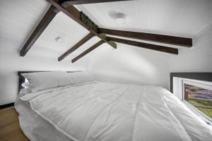 a bedroom with a white bed in a room at Rural Oasis - Tiny Home 2BR Cabin & Outdoor Firepit Experience in Palmwoods
