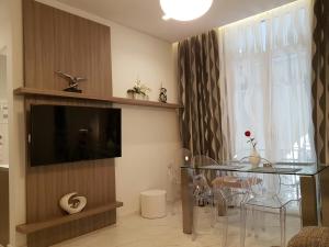 a dining room with a glass table and a television at Laura Aristotelous Square Apartment in Thessaloniki