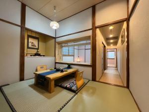 a room with a table and chairs and a hallway at Kimono Hotel Himeji 着物宿 in Himeji +21 photos