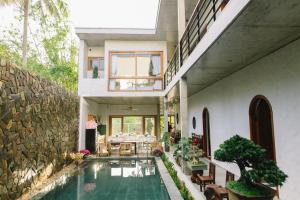 a house with a swimming pool and a dining room at Berry Boutique in Hue
