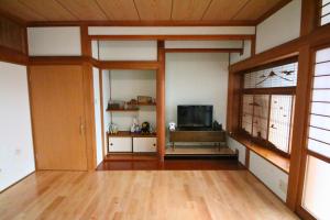 a living room with a television and a wooden floor at 蝶自来 in Yamaga