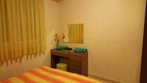 a bedroom with a bed and a vanity with a mirror at Beauty Apartment in Ohrid