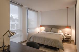 1 dormitorio con cama y ventana grande en ZITU 106 en Bogotá
