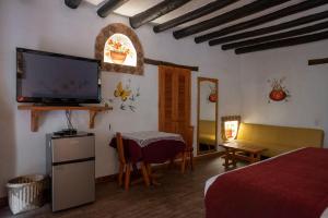 a bedroom with a bed and a flat screen tv at Hotel Spa Casa de Adobe Villa de Leyva in Villa de Leyva +219 photos