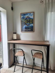 a table with two stools under a picture at Leu Cosy Coco in Saint-Leu