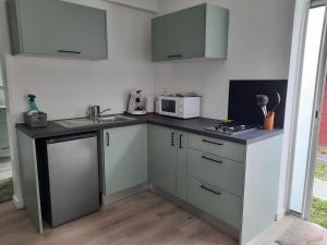 a small kitchen with a sink and a microwave at Leu Cosy Coco in Saint-Leu
