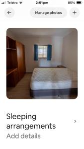 a bedroom with a bed with blue curtains at Beach house in Hallidays Point