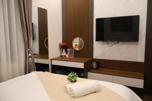 a hotel room with a bed and a flat screen tv at Lumi Home Đà Lạt in Da Thanh