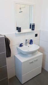 ゼーンデにあるApartment Bilmのバスルーム(白い洗面台、鏡付)