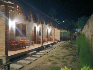ein Haus mit Tischen und Stühlen draußen bei Nacht in der Unterkunft Bitang's Guesthouse - Starlink Ready in Burgos