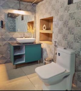 a bathroom with a white toilet and a sink at NAMOH e VIRAASAT in Chopta