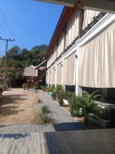 a building with white curtains on the side of it at Le Charme Pakbeng Villa in Pakbeng