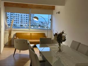 a dining room with a table and a couch at Frente al Mar Servicio de Playa Playa Mansa A pasos de Gorlero y Puerto Garage Limpieza diaria in Punta del Este