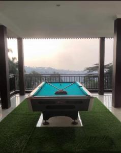 a pool table in a room with a balcony at Villa Brown Cisarua in Paragajen