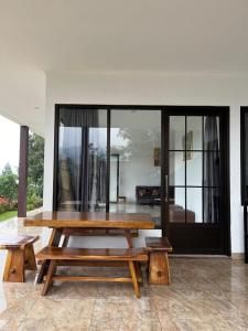 a wooden table and benches in a room at Villa Brown Cisarua in Paragajen