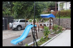 a playground with a blue slide in a yard at Villa Brown Cisarua in Paragajen