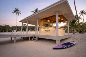 a surfboard laying on the sand in front of a building at Anaya Koh Rong in Koh Rong Island +65 photos