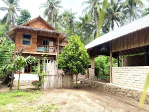 a wooden house with a fence in front of it at Lombok House Mentigi in Teluknarat