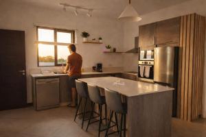 a man standing in a kitchen with a counter at Sunset Haven in Flic-en-Flac